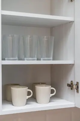 a shelf with bowls and cups on it at Apartament Park Zdrojowy 11 - NOWOŚĆ in Rabka
