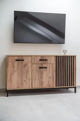 a flat screen tv on top of a wooden cabinet at Apartament Park Zdrojowy 11 - NOWOŚĆ in Rabka