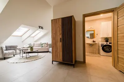 a living room with a table and a dining room at Apartament Park Zdrojowy 11 - NOWOŚĆ in Rabka