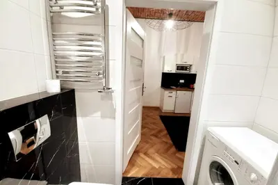 a small white kitchen with a washer and dryer at Old Town Apartment Lubicz Street L2a in Kraków