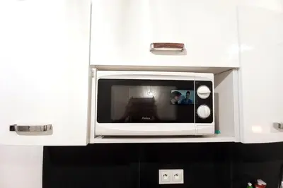 a microwave in a cabinet with a picture in it at Old Town Apartment Lubicz Street L2a in Kraków