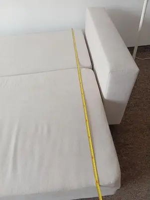a white bed with a yellow measuring tape on it at Królewska in Kraków