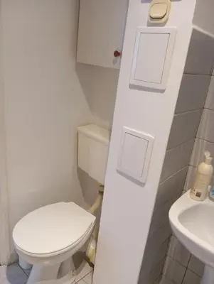a white bathroom with a toilet and a sink at Królewska in Kraków
