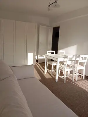 a white room with a table and white chairs at Królewska in Kraków