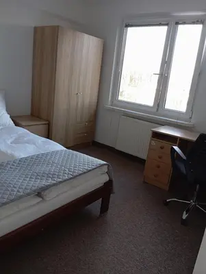 a bedroom with a bed and a desk and a chair at Królewska in Kraków