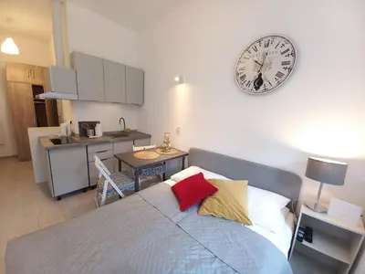 a bedroom with a bed and a clock on the wall at Stary Krakow - Sołtyka S2a in Kraków