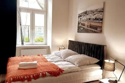 a bedroom with a bed with an orange blanket on it at Apartment by Wawel castel - G1a in Kraków