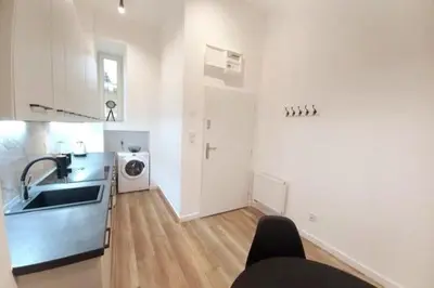 a white kitchen with a sink and a counter top at Apartment by Wawel castel - G1a in Kraków