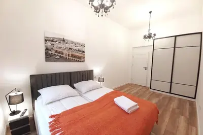 a bedroom with a large bed with an orange blanket at Apartment by Wawel castel - G1a in Kraków