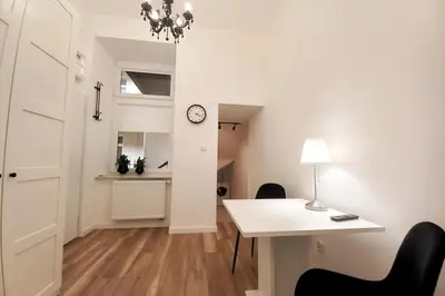 a room with a table and a clock on the wall at Cozy apartment by Wawel castel - G1b in Kraków