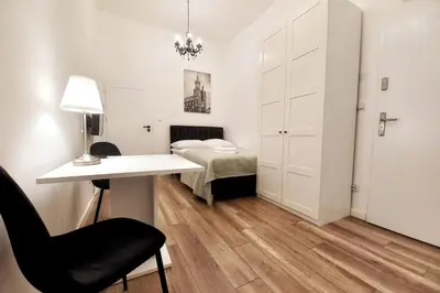 a bedroom with a bed and a desk with a chair at Cozy apartment by Wawel castel - G1b in Kraków