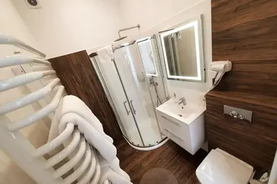 a white bathroom with a shower and a sink at Bosacka - old town cozy apartment B16 in Kraków