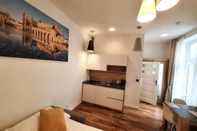 a room with a kitchen and a living room with a table at Bosacka - old town cozy apartment B16 in Kraków