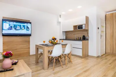 a kitchen with a table and chairs and a television at Bosacka old town apt - B17 in Kraków