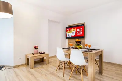 a dining room with a table and white chairs at Bosacka old town apartment - B28 in Kraków