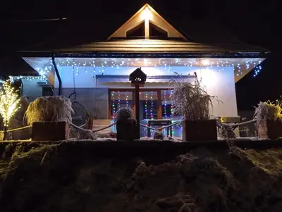 a house decorated with christmas lights at night at Zawoja domki z jacuzzi, domek w stylu góralskim in Zawoja