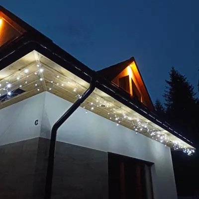 a house with lights on the roof at night at Zawoja domki z jacuzzi, domek w stylu góralskim in Zawoja