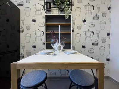 a dining room table with two chairs and a wall with a wallpaper at Apartament nieopodal Centrum Nauki Cogiteon in Kraków