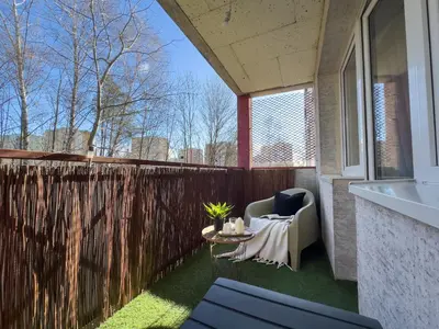 a patio with a chair and a table and a fence at Apartament nieopodal Centrum Nauki Cogiteon in Kraków