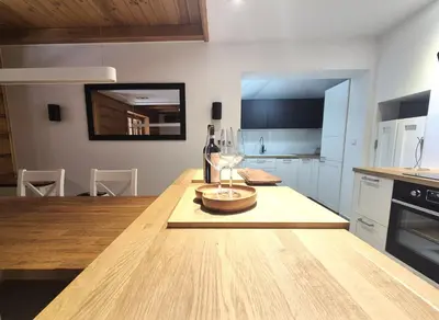 a kitchen with a wooden table with wine glasses on it at Forest House- dom nad górskim potokiem in Juszczyn