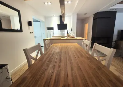 a dining room and kitchen with a wooden table and chairs at Forest House- dom nad górskim potokiem in Juszczyn
