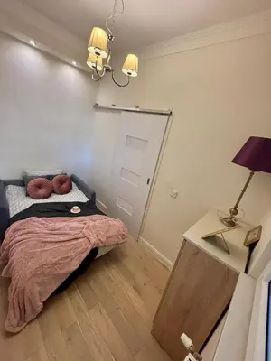 a bedroom with a bed and a table with a lamp at Vintage Lubicz Apartment in Kraków