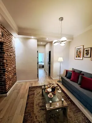 a living room with a couch and a brick wall at Vintage Lubicz Apartment in Kraków