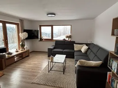 a living room with a couch and a table at Apartament pod lasem - przy szlaku na Turbacz, w pobliżu wyciągów narciarskich in Nowy Targ