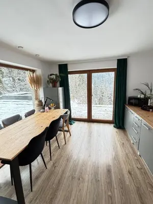 a dining room with a wooden table and chairs at Apartament pod lasem - przy szlaku na Turbacz, w pobliżu wyciągów narciarskich in Nowy Targ