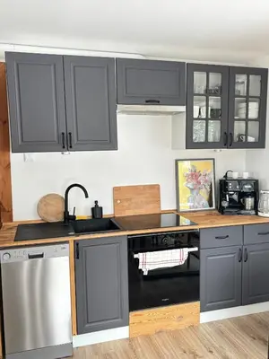 a kitchen with gray cabinets and a stove top oven at Apartament pod lasem - przy szlaku na Turbacz, w pobliżu wyciągów narciarskich in Nowy Targ