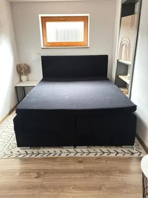a bedroom with a black bed in a room at Apartament pod lasem - przy szlaku na Turbacz, w pobliżu wyciągów narciarskich in Nowy Targ