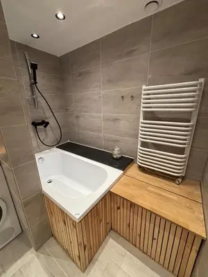 a bathroom with a bath tub and a towel at Apartament pod lasem - przy szlaku na Turbacz, w pobliżu wyciągów narciarskich in Nowy Targ