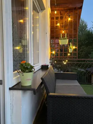 a porch with a table and a window with a potted plant at Dom Na Wzgórzu in Poręba