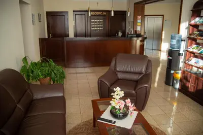 a waiting room with a couch and chairs in a hospital at Dom rekolekcyjny Vincentinum in Krzeszowice