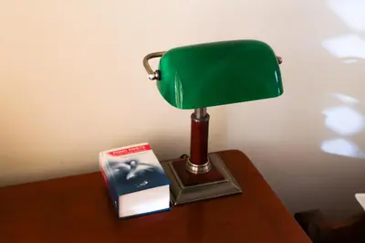 a green lamp sitting on a table with a book at Dom rekolekcyjny Vincentinum in Krzeszowice