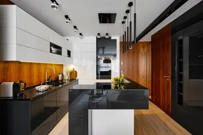 a kitchen with a black counter top and wooden cabinets at Kazimierz Comfort Flat in Kraków