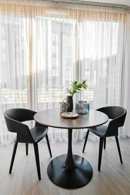 a table and chairs in a room with a window at Kazimierz Comfort Flat in Kraków