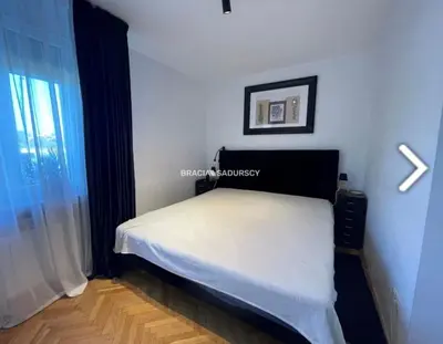 a bedroom with a white bed with a window at Biały Lotos in Kraków