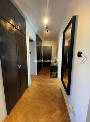 a hallway with black doors and wooden floors at Biały Lotos in Kraków