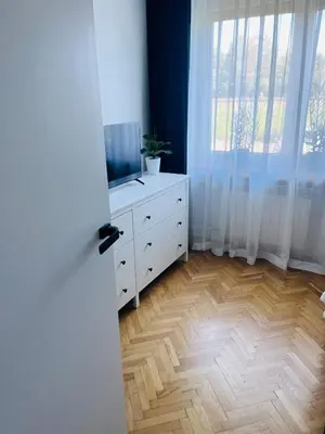 a room with a dresser with a tv and a window at Biały Lotos in Kraków