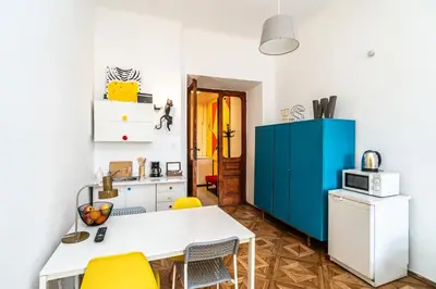 a kitchen with a white table and yellow chairs at ShortStayPoland Old Town C1 in Kraków