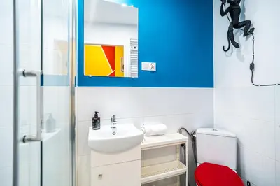 a bathroom with a sink and a red stool at ShortStayPoland Old Town C1 in Kraków