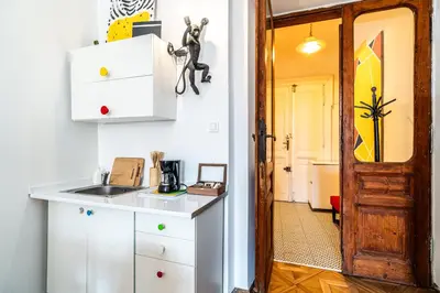 a kitchen with white cabinets and a door leading into a hallway at ShortStayPoland Old Town C1 in Kraków