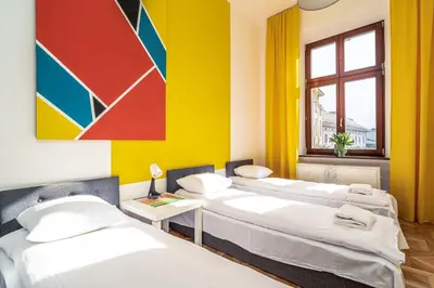two beds in a room with a colorful wall at ShortStayPoland Old Town C1 in Kraków