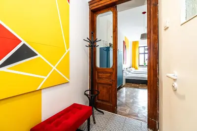 a colorful hallway with a red bench and a mirror at ShortStayPoland Old Town C1 in Kraków