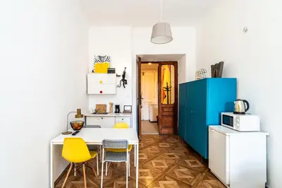 a kitchen with yellow chairs and a white and blue refrigerator at ShortStayPoland Old Town C1 in Kraków