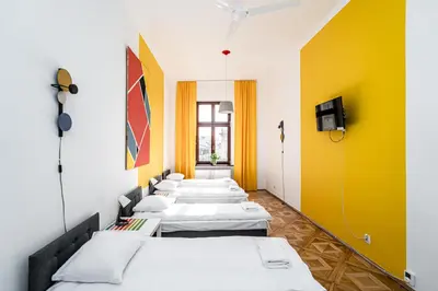 a row of beds in a room with yellow walls at ShortStayPoland Old Town C1 in Kraków
