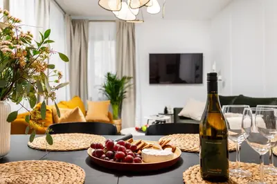 a table with a bottle of wine and a plate of food at Vistula Suite l A Lovely Place to Be in Kraków