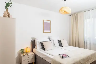 a white bedroom with two beds and a window at Vistula Suite l A Lovely Place to Be in Kraków