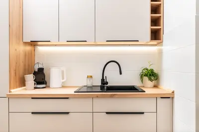 a kitchen with white cabinets and a sink at Vistula Suite l A Lovely Place to Be in Kraków